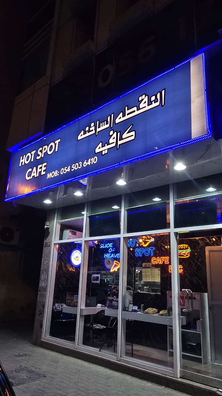 Hot Spot Cafe storefront at night with signature blue signage